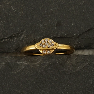 Detailed view of adjustable 18k gold planet ring with crystal stones on a rock surface