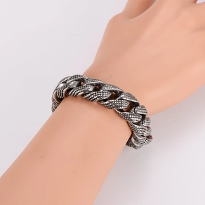 Rugged stainless steel bracelet with snake scale texture shown on a mannequin hand