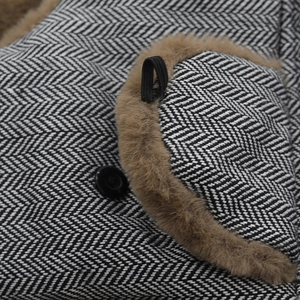 Macro detail of herringbone wool fabric with brown faux fur trim and elastic strap