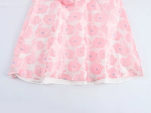 Detailed macro of pink tulle hem with floral jacquard and blue heart embroidery
