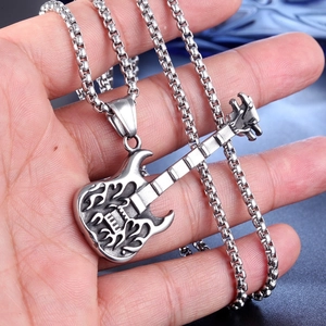 Detail of silver stainless steel flame guitar pendant on a palm with beaded chain link
