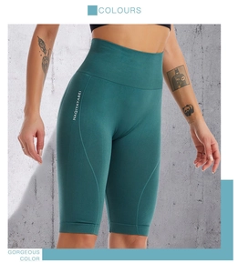 Macro detail of high-waist seamless compression sports shorts in deep emerald green