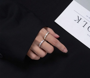 Close-up of gold and silver S925 rings with square pavé diamonds on a model's hand