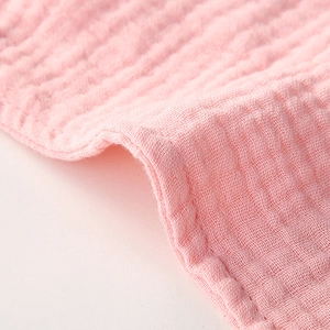 Macro detail of soft pink double-layer cotton gauze fabric with crinkle texture