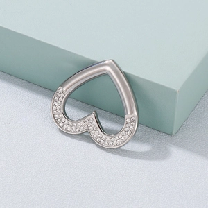 Elegant silver heart pendant with sparkling side crystals displayed on a soft grey surface