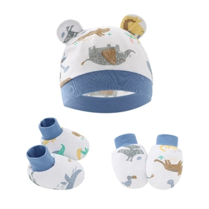 Dettaglio set neonato in cotone bianco con cappello, guanti, calzini e stampe animali