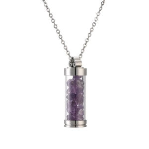 Macro shot of stainless steel perfume bottle pendant filled with purple crystal stones