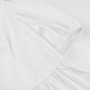 Gros plan sur la manche bouffante blanche avec poignet élastique et volant de tissu