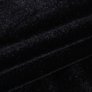 Gros plan du tissu en velours noir montrant la texture riche et l'éclat doux de la robe