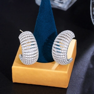 Macro shot of silver C-shaped earrings featuring dense rows of multi-row white zircon stones