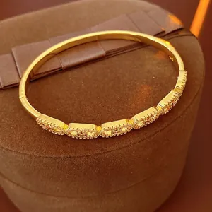 Gold-plated bracelet with cubic zirconia linked squares on a brown velvet box