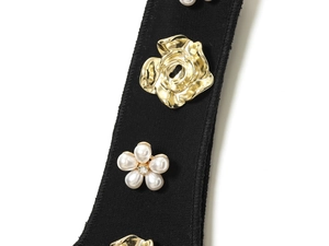 Detailed close-up of a black fabric strap with golden roses and pearl flower accents
