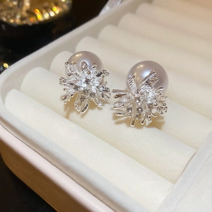 Macro detail of snowflake pearl earrings with silver metal and sparkling crystals