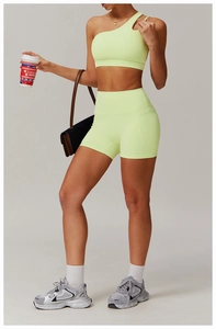 Detailed view of neon green one-shoulder sports bra and high-waist fitness shorts set