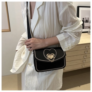 Detail of crossbody bag featuring heart chain hardware and white contrast stitching