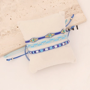 Three-piece bohemian beaded bracelet set featuring blue and gold crystals in hand-woven style