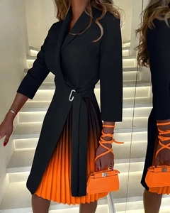 Detail of V-neck dress featuring orange-black gradient pleated hem and belted waistline