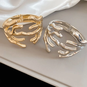 Detailed macro view of coral branch design bracelets in polished gold and silver finish