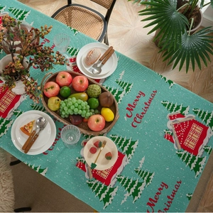 Blue Christmas tablecloth with trees and houses print on a festive dining table setting