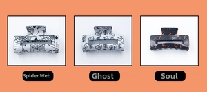 Detailed view of Halloween hair claws with spider web, ghost, and spooky face patterns