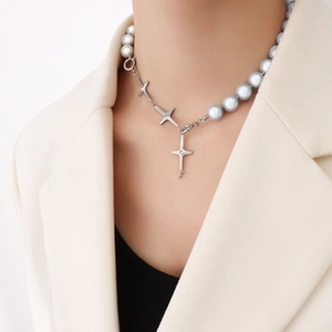 Detail of pink fish bracelet with blue cat eye stones and cross star charms