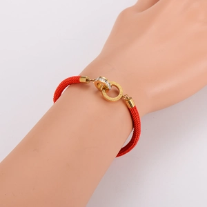 Red braided cord bracelet with interlocking gold Roman numeral rings and white crystals