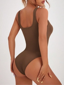 Detail of ribbed seamless brown yoga bodysuit featuring open back and high stretch fabric