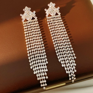 Dettaglio di orecchini a nappa vintage con strass scintillanti su astuccio in pelle