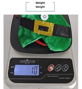 Weight measurement of a green Christmas elf hat wine bottle cover on a digital scale
