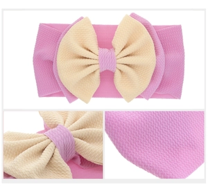 Detail view of pink and beige double-layered bow baby headband with waffle texture fabric