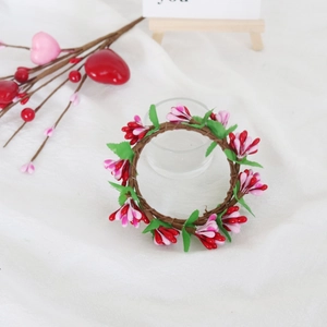 Floral candle ring with red and pink buds on a green leaf wreath for Valentine's Day decor