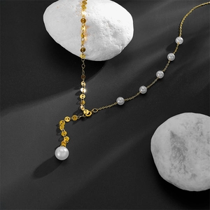 Detail of a golden double-layered pearl necklace on grey stone display props