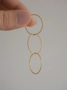 Close-up of three stackable gold rings with textured surface and minimalist design