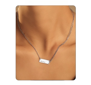 Close-up of a silver rectangular pendant necklace with ChuDong engraving on a model