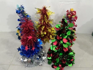 Close-up of five colorful mini sequined trees with stars and tinsel for holiday decor