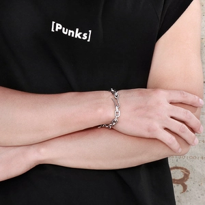Close-up of silver chunky rectangular chain bracelet with S-hook clasp in punk style