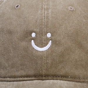 Distressed khaki washed cotton baseball cap with white embroidered smiley face