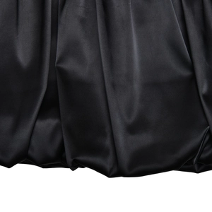 Macro view of black silk-like satin fabric texture with soft drapes and elegant sheen