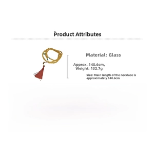 Détail du collier de perles en verre jaune avec pompon rouge et longueur de 140,6 cm