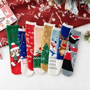 Set of eight fuzzy Christmas socks with reindeer and santa patterns in festive gift box decor