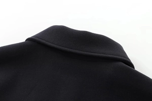 Gros plan détaillé sur le tissu en laine de qualité et les coutures du col de ce manteau