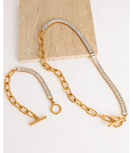 Detail of gold chain necklace and bracelet set with zircon stones and OT buckle clasp