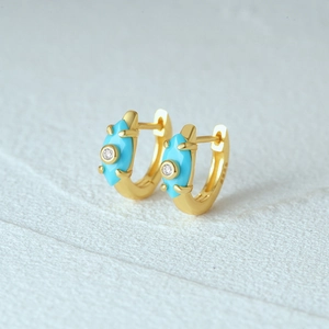 Macro shot of S925 sterling gold earrings featuring blue marquise cut turquoise stones