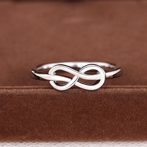 Close-up van een zilveren infinity ring met gepolijste afwerking en elegant symbool
