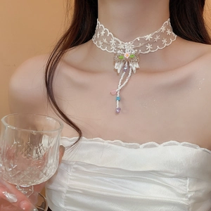 Close-up of lace choker with bow, pearls, and a purple heart pendant on neck
