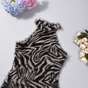 Dettaglio dell'abito in maglia zebrata con texture soffice e bordi con frange morbide