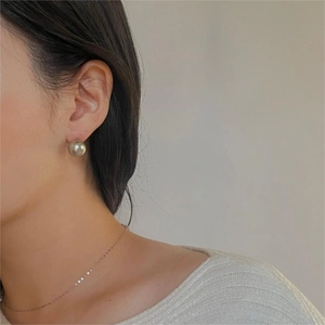 Elegant 925 sterling silver earring featuring a large glass pearl on a female model