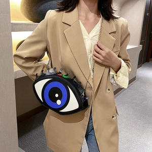Fashionable blue eye-shaped crossbody chain bag showcased by model in casual style