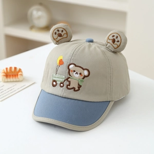 Detail of baby bear baseball cap with cartoon embroidery and 3D ears on cotton fabric