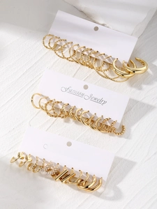 Detail view of a 16-piece gold earring set featuring pearl hoops and rhinestone studs
